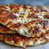 Warm The Best Easy Garlic Naan Bread ready to scoop up chicken curry or lentil dal.
