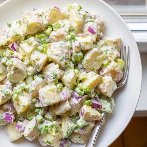 Chilled American potato salad with tender boiled potatoes, celery, red onion, and chopped eggs.