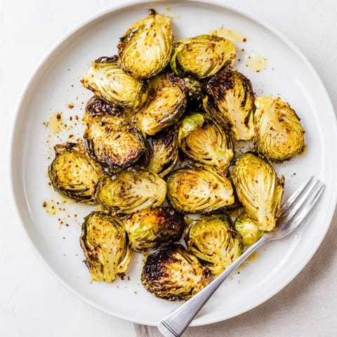Golden brown Roasted Brussels Sprouts with crispy edges on a rustic plate, garnished with parmesan.