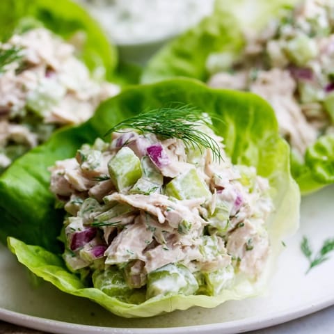 Colorful Dill Pickle Chicken Salad Lettuce Cups plated with juicy chicken, crunchy celery, and red onion in fresh leaves.