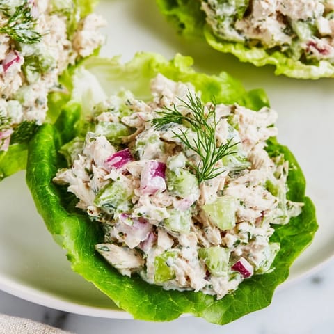 Crisp butter lettuce cups overflowing with creamy Dill Pickle Chicken Salad, garnished with fresh dill and chopped pickles.