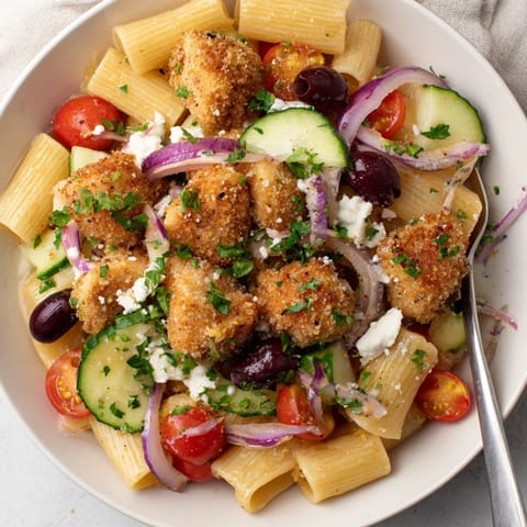 In this Crispy Chicken Greek Pasta, tender pasta is tossed with juicy chicken, crunchy vegetables, and a zesty red wine vinegar dressing.