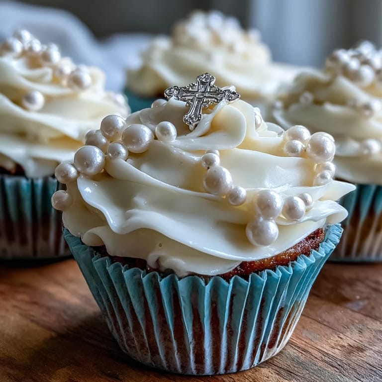 Delicate vanilla mini cupcakes topped with smooth buttercream and fondant rosary toppers for a sacred First Communion dessert.