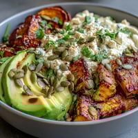 Golden roasted sweet potato cubes, creamy avocado slices, and a dollop of cottage cheese in a Hot Honey Sweet Potato Bowl.